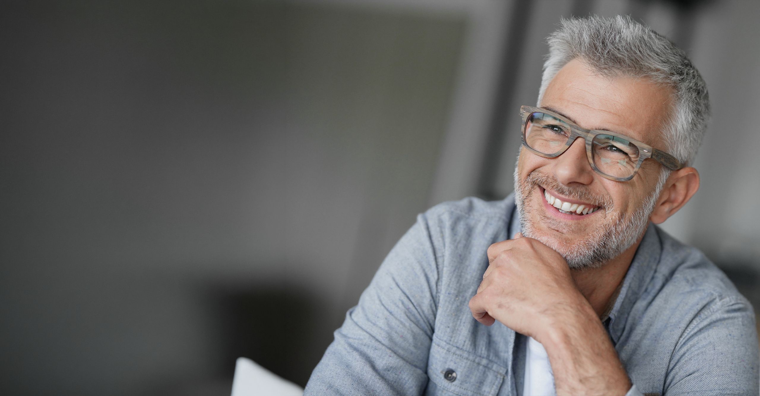 Mann mittleren Alters mit moderner Brille in Holzoptik